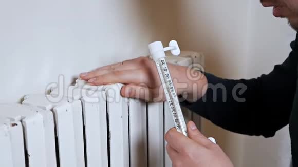 人检查加热电池的温度寒冷的冬天寒冷的房子公寓一个人在附近取暖视频的预览图