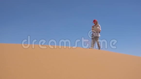 运动的女人沿着撒哈拉沙漠散步视频的预览图