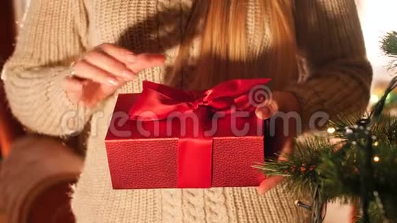 特写4k镜头的东女打开红色盒子与礼物和看里面圣诞或新年的完美镜头视频的预览图