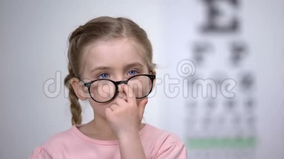 可爱的女孩子微笑调整眼镜成功的视力治疗视频的预览图