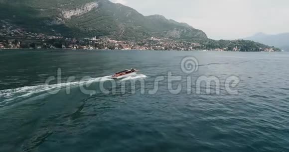 旧红木摩托艇在科莫湖上漂浮背景是群山视频的预览图