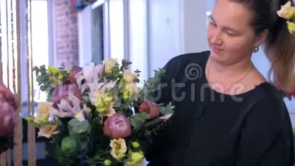 花商女人在花店里做大花束对着镜头微笑视频的预览图