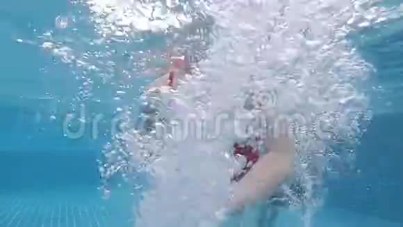 小女孩在游泳池里潜水和游泳视频的预览图