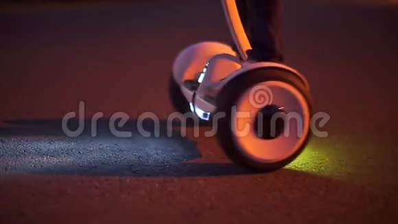 一个骑着头灯的陀螺滑板车的男孩在夜间最大转弯视频的预览图