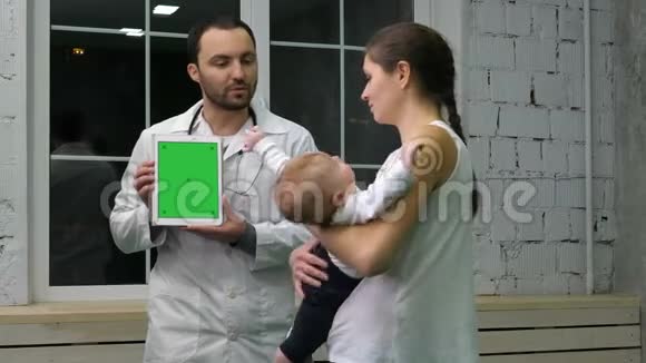 医生在药片上显示母亲和孩子的医疗结果绿屏模拟显示视频的预览图