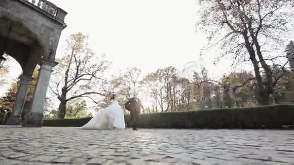 新娘和新郎在婚礼当天快乐地沿着一条小路奔跑不同的夫妇牵着手私奔视频的预览图