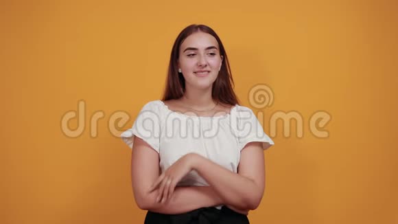 迷人的白种人年轻女子吹着嘴唇在橙色的墙上亲吻空气视频的预览图