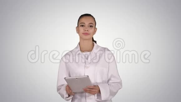 快乐女医生使用平板电脑在梯度背景上滑动页面视频的预览图