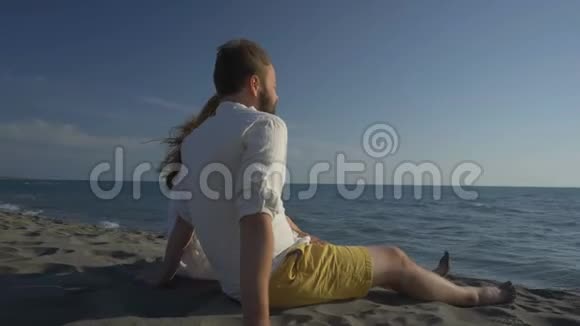 一对夫妇坐在沙滩上看着大海视频的预览图