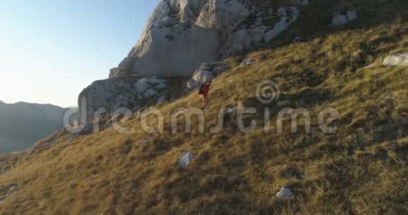 一名男子在山上行走的空中射击视频的预览图