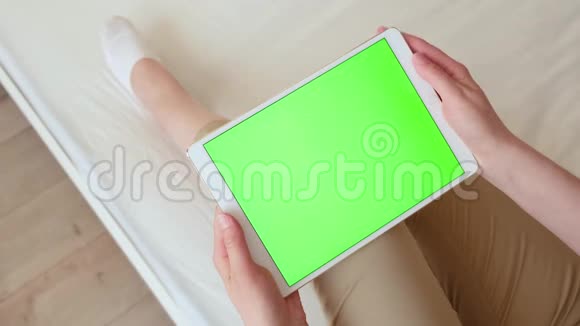女人手里拿着平板电脑手里拿着绿色的屏幕色度键视频的预览图
