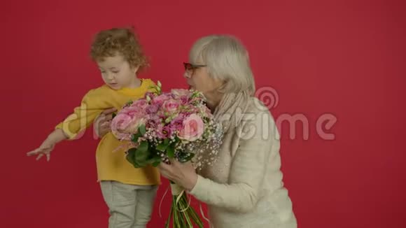祖母手捧鲜花母亲拥抱孩子视频的预览图