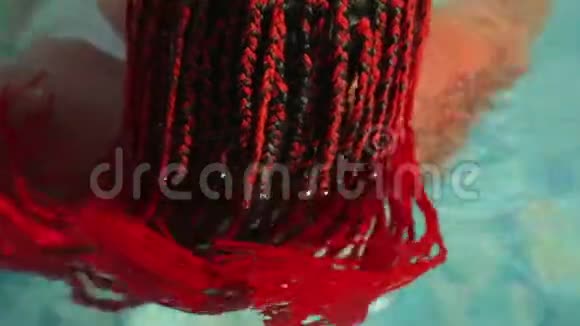 从后面射来的一个绣球花在泳池里的红发女人视频的预览图