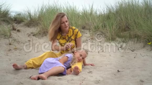 慈爱的母亲在沙丘上轻松地抚摸女儿的头视频的预览图