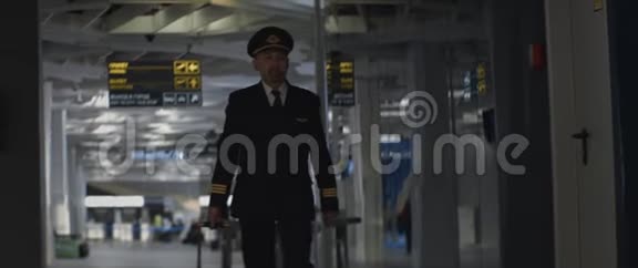 戴着顶帽的机长通过机场候机楼前往视频的预览图