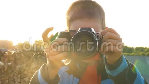 小孩拿着数码相机在大自然中拍照视频的预览图