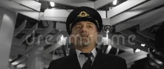 身着制服戴着帽子的老年飞行员在机场候机楼前行走摸着领带视频的预览图