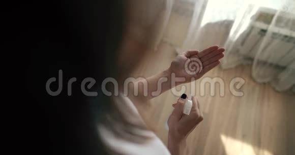 一个女孩用防腐剂喷洒她的手以消毒冠状病毒COVID19流行病视频的预览图