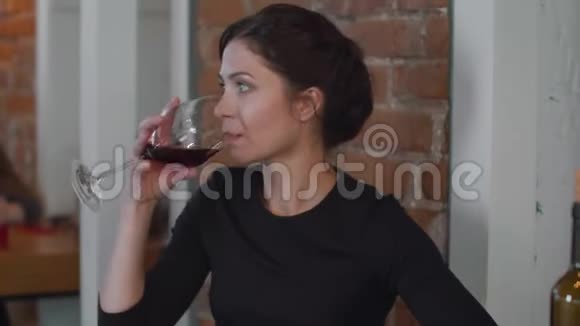 孤独的女人喝着酒看着电话视频的预览图