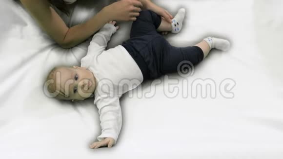 婴儿躺在床上母亲在他身边照顾视频的预览图