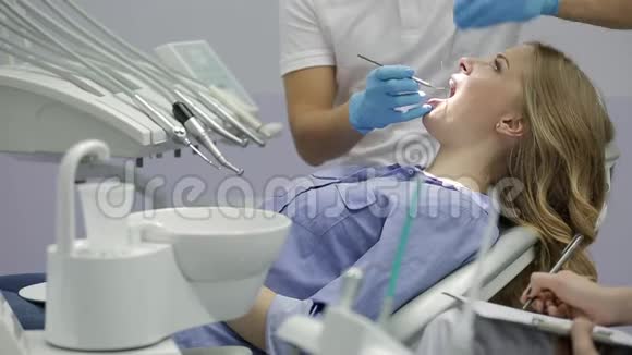 漂亮女人牙科诊所检查牙齿视频的预览图