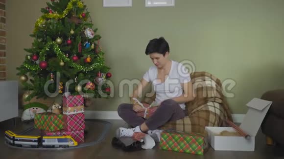 年轻女子在家用纸包圣诞礼物视频的预览图