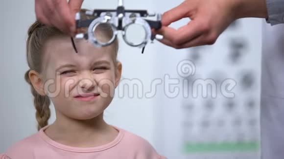 医生给孩子戴上光学试验架诊断近视视力模糊视频的预览图