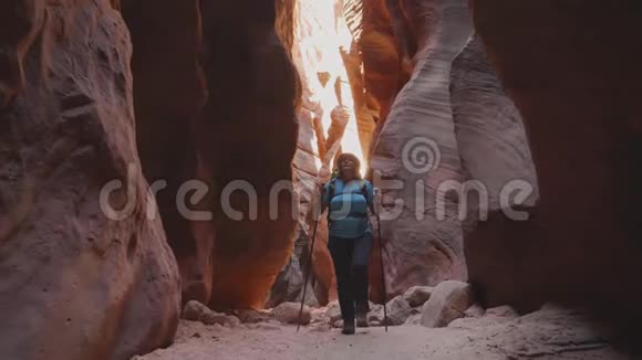 旅游徒步旅行在干河床深槽峡谷与橙色光滑岩石视频的预览图