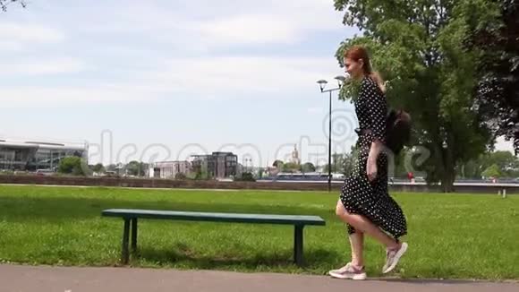 快乐美丽健康的女孩跳舞在公园里散步视频的预览图