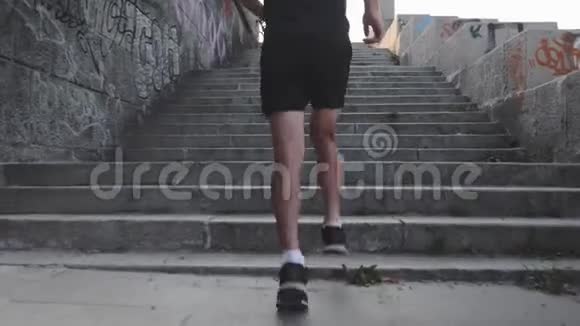 肌肉发达晒黑的男性腿上楼梯特写后景的运动有力的男性腿苗条的运动员跑上楼梯视频的预览图