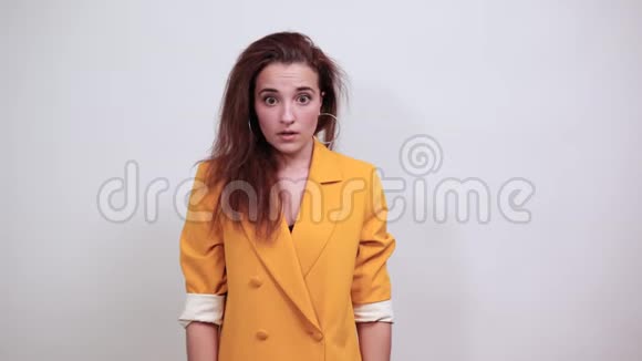 穿着黄色夹克的糊涂少女直视着神情震惊视频的预览图