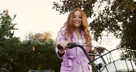 有雀斑的红发女孩骑着一辆带篮子的城市自行车视频的预览图