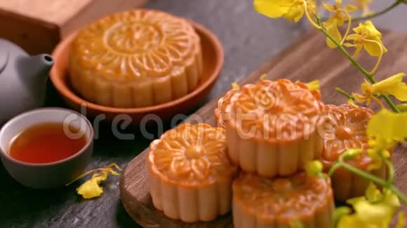 美丽的月饼在一个木盘上茶和花在黑色背景上中国传统中秋节视频的预览图