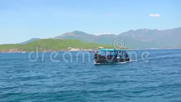 船漂浮在碧海的青山景观上碧波荡漾的海水青山碧空视频的预览图