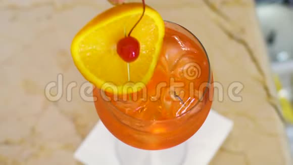 酒保用水果片装饰鸡尾酒放一根饮料吸管视频的预览图