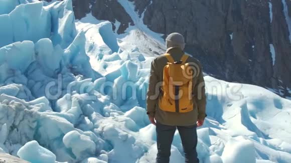 一位带着黄色背包的游客看着挪威的斯瓦尔蒂森冰川视频的预览图