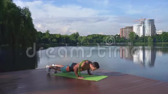 裸胸运动员在瑜伽垫上做俯卧撑视频的预览图