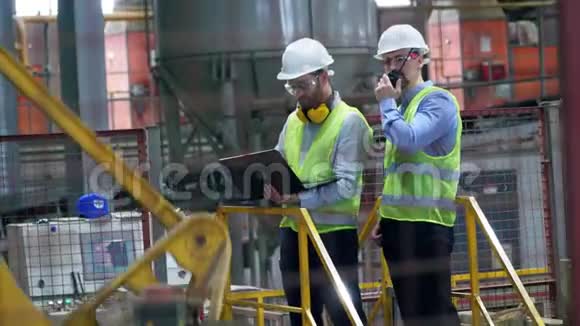 工业设施有两名技术人员同事在工作服交谈视频的预览图