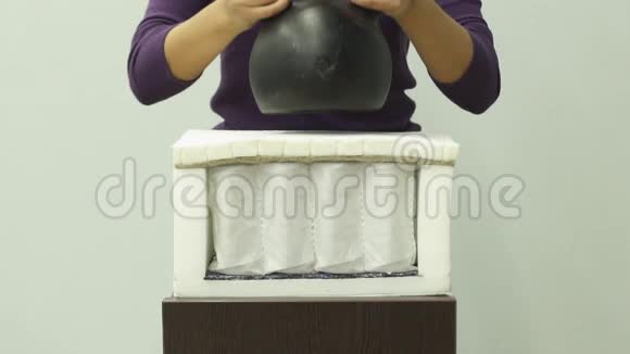 女人的手把沉重的重量放在矫形泡沫床垫上视频的预览图