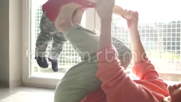 妈妈和他的儿子玩积极的游戏体操带着一个孩子在球场上这个男孩躺在母亲腿上这就是视频的预览图