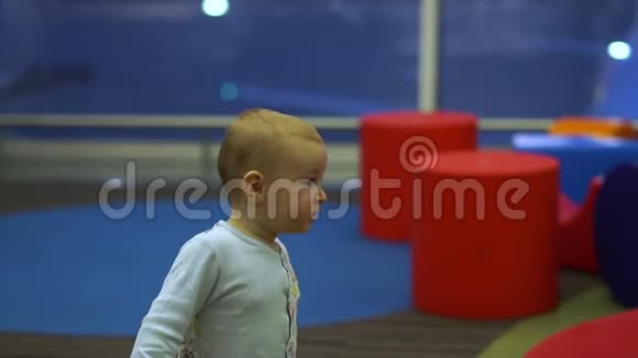 一个可爱的男孩慢悠悠地站在机场的儿童游乐区视频的预览图