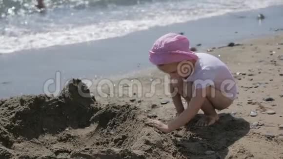 小可爱的女孩在海边的海滩上玩沙子视频的预览图
