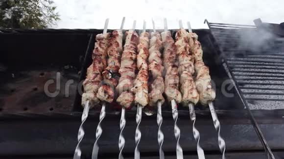 肉是穿在串上的慢慢地烤在木炭烤架上视频的预览图