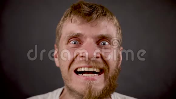 英俊的留胡子的嬉皮士男子的笑容就像在黑人工作室里疯狂的微笑视频的预览图