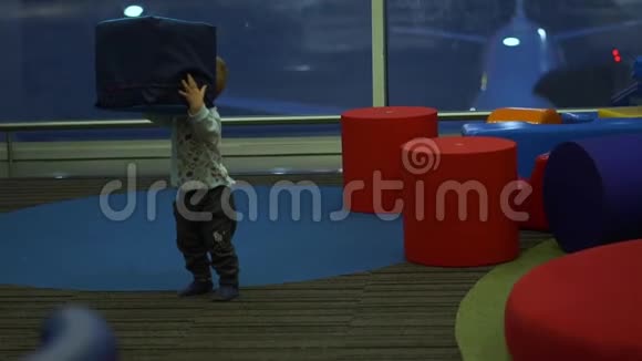 男孩在机场的儿童游乐区玩大方块慢动作视频的预览图