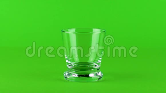 倒入糖丸玻璃厚底绿色对比背景慢速视频的预览图