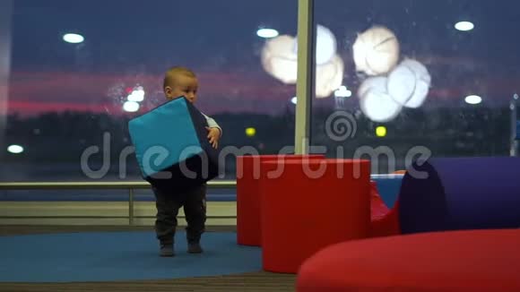 小可爱的男孩在机场的儿童游乐区玩大方块视频的预览图