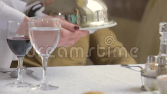 服务员端桌上的菜拿起一个豪华闪亮的铃铛吃东西视频的预览图