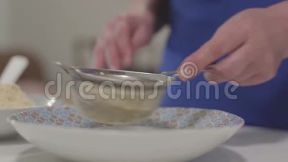 成熟的白种人女性手筛面粉的特写资深女性退休人员在家烘焙爱好休闲活动视频的预览图