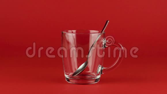 把糖倒在杯子里茶匙放在红色的对比背景上概念视频的预览图